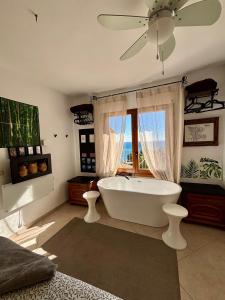 a bathroom with a white tub and a window at Casa Halcón in Jávea