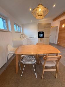 une cuisine et une salle à manger avec une table et des chaises en bois dans l'établissement Ferienwohnung Balkonien, à Wangen im Allgäu
