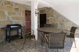 a table and chairs in a room with a stone wall at Finca Mit Terrasse in Tondela +20 photos