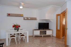 ein Wohnzimmer mit Tisch und Fernseher in der Unterkunft Ferienhaus für 6 Personen ca 88 m in Estrella de Mar, Murcia Costa Calida in Los Urrutias