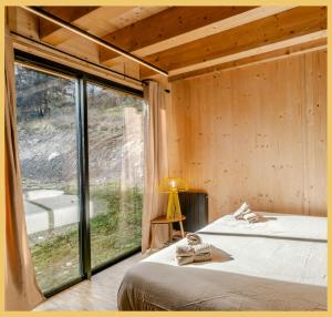una camera da letto con un letto e una grande finestra di Le Château Ambulant a La Baume