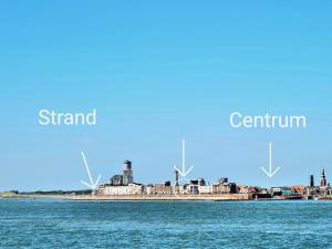 a city on the water with windmills in the background at Studio Zeezicht in Vlissingen +26 photos