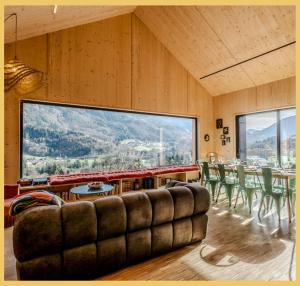 un soggiorno con un divano e una grande finestra di Le Château Ambulant a La Baume