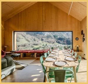 una sala da pranzo con tavolo e sedie e una grande finestra di Le Château Ambulant a La Baume