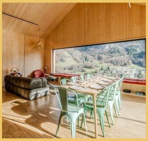 un tavolo e delle sedie in una stanza con una grande finestra di Le Château Ambulant a La Baume