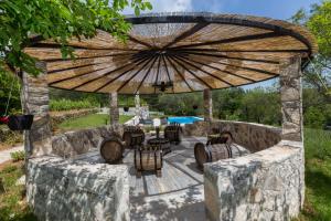 an outdoor patio with a large wooden umbrella at Historische Steinvilla Heaven Für 11 Personen in Gornji Muć
