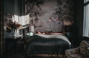 Un dormitorio con una cama con un cuadro en la pared. en Häckeberga Slott, en Genarp