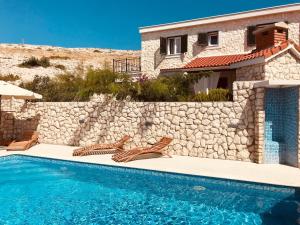 eine Villa mit Swimmingpool und ein Haus in der Unterkunft Ferienhaus mit Terrasse und Pool, strandnah und ruhig gelegen in der Nähe von Novalja in Novalja