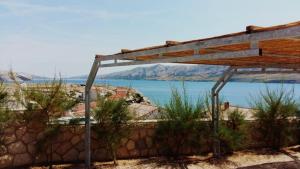 eine Holzpergola mit Blick aufs Wasser in der Unterkunft Ferienhaus mit Terrasse und Pool, strandnah und ruhig gelegen in der Nähe von Novalja in Novalja + 33 Fotos
