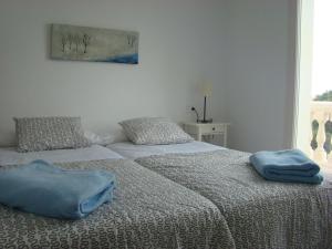 Zwei blaue Handtücher auf zwei Betten in einem Schlafzimmer in der Unterkunft Helles und modern eingerichtetes Ferienhaus mit eigenem Pool und sonniger Terrasse in Cala Bona