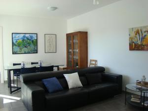 ein Wohnzimmer mit einer schwarzen Couch und einem Tisch in der Unterkunft Helles und modern eingerichtetes Ferienhaus mit eigenem Pool und sonniger Terrasse in Cala Bona