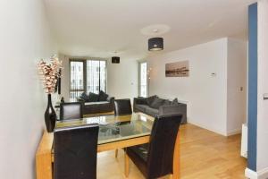 ein Esszimmer mit Tisch und Couch in der Unterkunft Executive apartment in central Milton Keynes in Milton Keynes + 2 Fotos