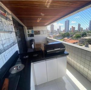 a kitchen with a counter with a sink and a window at Carnatal Agora- 30m da Arena das Dunnas in Natal +1 photo
