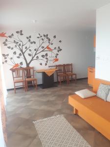 - un salon orné d'une fresque murale représentant les arbres dans l'établissement Charmante Wohnung Adriana F, à Dobreć