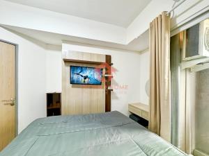 Jombang-kulonにあるStrategic Akasa 1BR Apt BSD W Pool & Gymのベッドと壁掛けテレビのある寝室 +12枚の写真
