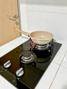 Jombang-kulonにあるStrategic Akasa 1BR Apt BSD W Pool & Gymのキッチンのコンロの上の鍋