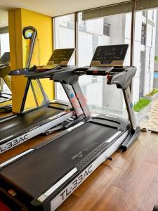 Jombang-kulonにあるStrategic Akasa 1BR Apt BSD W Pool & Gymのジムのトレッドミルに置かれた2台のノートパソコン