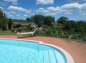 une chaise assise sur une terrasse à côté d'une piscine dans l'établissement Podere Vecciale, à Cavriglia