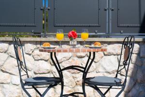einen Tisch mit zwei Gläsern Orangensaft und Rosen in der Unterkunft Ferienhaus mit Privatpool für 6 Personen ca 120 m in Garica, Kvarner Bucht Krk in Garica + 28 Fotos