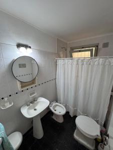 une salle de bain avec un lavabo, des toilettes et un miroir dans l'établissement Casa DorisHouse, à Necochea