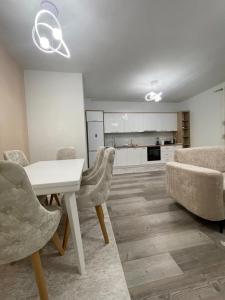 ein Wohnzimmer mit einem weißen Tisch und Stühlen in der Unterkunft Olti in Peshkopi