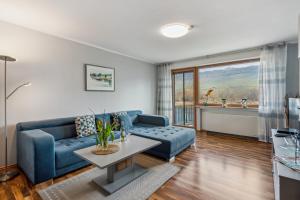 un salon avec un canapé bleu et une table dans l'établissement Ferienwohnung Mit Balkon Und Schönem Moselblick, à Schleich