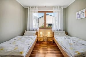 deux lits dans une chambre avec une fenêtre dans l'établissement Ferienwohnung Mit Balkon Und Schönem Moselblick, à Schleich