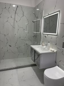 ein weißes Badezimmer mit Waschbecken und Toilette in der Unterkunft Olti in Peshkopi