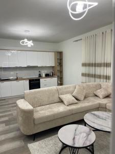 a living room with a couch and two tables at Olti in Peshkopi +7 photos