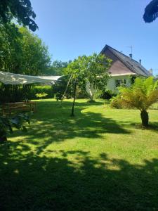 a green yard with a house and a tree at Avel Glaz - Chambres d'hôtes pour randonneurs et cyclistes in Morlaix