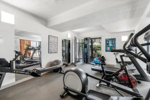 un gimnasio con varias cintas de correr y bicicletas estáticas en Laguna Edge - Tranquil Poolside Escape by the Sea, en Trinity Beach