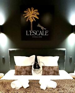 ein Schlafzimmer mit einem Bett mit einer Palme an der Wand in der Unterkunft Escale Singulière - Luxe & balnéo à Sète in Sète