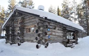 une cabane en rondins avec de la neige au-dessus dans l'établissement Kelosix, à Vuostimo