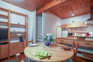 une cuisine avec une table en bois et des fleurs. dans l'établissement La Maison de Julie - Proche Sites Historique, à Septfonds