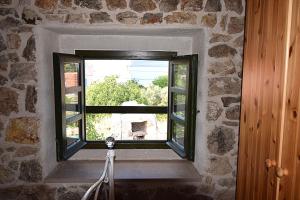 a window in a stone wall with a horse looking out at Ferienhaus In Dobropoljana Mit Privatem Pool in Dobropoljana