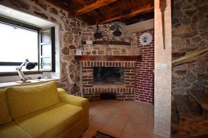 a living room with a couch and a brick fireplace at Ferienhaus In Dobropoljana Mit Privatem Pool in Dobropoljana +31 photos
