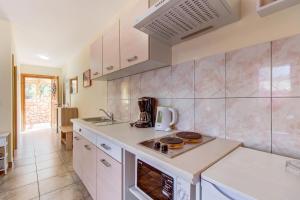 a kitchen with white cabinets and a counter top at Appartement Casper Mit Terrasse, Garten Und Grill in Veli Lošinj +10 photos