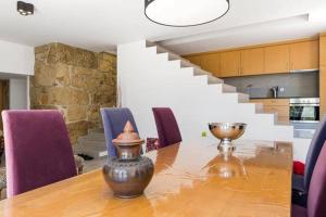 a dining room table with purple chairs and a staircase at Renoviertes Landhaus Für 4 Personen In Tondela in Tondela