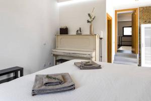 a bedroom with a bed with two towels and a piano at Renoviertes Landhaus Für 4 Personen In Tondela in Tondela