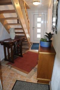 ein Flur mit einer Treppe mit einer Topfpflanze auf einem Tisch in der Unterkunft Modern ausgestattetes Ferienhaus mit vier Sternen zertifiziert und mit einer eigenen Terrasse in Zainingen