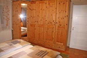 Zimmer mit 2 Betten und einem großen Holzschrank in der Unterkunft Modern ausgestattetes Ferienhaus mit vier Sternen zertifiziert und mit einer eigenen Terrasse in Zainingen