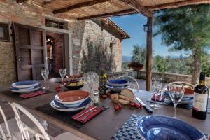 - une table en bois avec des verres à vin et de la nourriture dans l'établissement Podere Vecciale, à Cavriglia