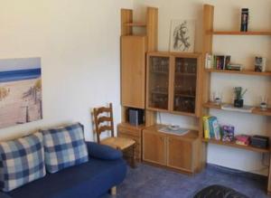 - un salon avec un canapé bleu et une armoire en bois dans l'établissement Appartement Mit Garten, Grill Und Terrasse, à Parey