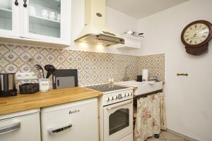 a kitchen with a stove and a clock on the wall at Landhaus Lietzow Haus Cottage Garden in Lietzow
