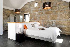 a bedroom with a large bed and a stone wall at Renoviertes Landhaus Für 7 Personen In Tondela in Tondela