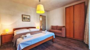 une chambre d'hôtel avec un lit et une chaise dans l'établissement Große Wohnung In Palit Mit Privatem Balkon, à Palit