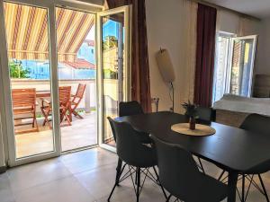 une salle à manger avec une table et des chaises et un balcon dans l'établissement Große Wohnung In Palit Mit Privatem Balkon, à Palit