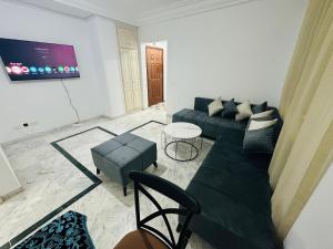 ein Wohnzimmer mit Sofa und Tisch in der Unterkunft Eden Cozy Airport in El Aouina Station