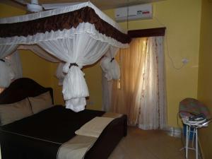 a bedroom with a bed with a canopy at Barizi Cottage in Mombasa