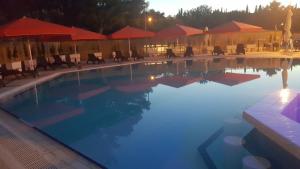 a large swimming pool with chairs and umbrellas at Apartment Bella Mit Balkon Und Terrasse In Necujam in Nečujam